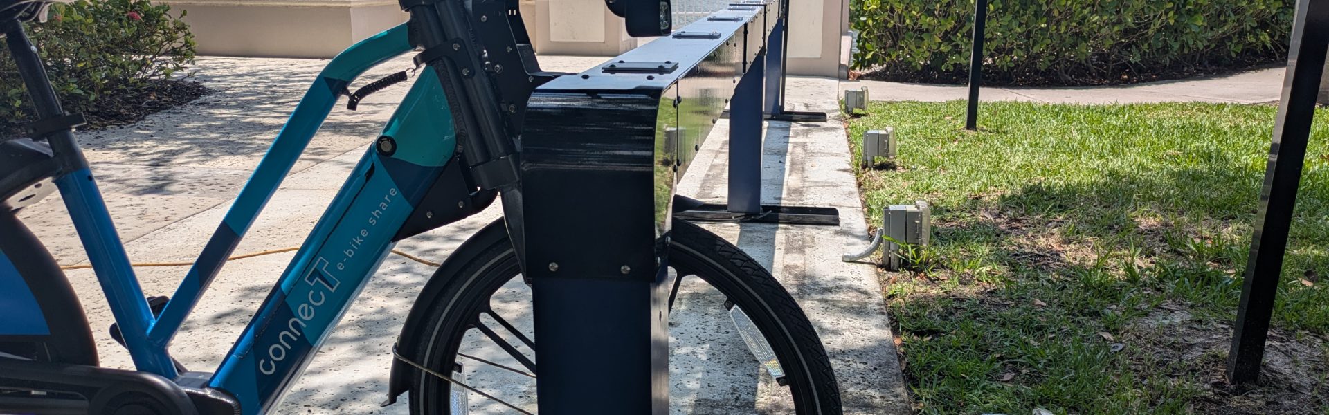 E-bike locked into a Juise charging dock on a grass verge
