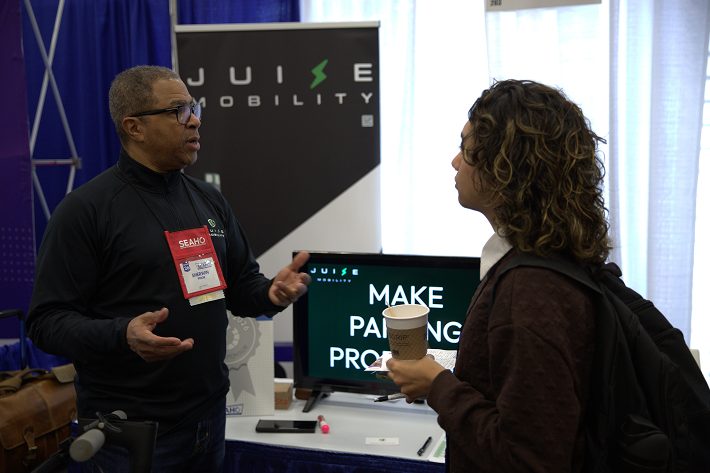 Juise Mobility team member speaking with a visitor at a conference booth