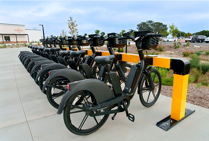 Row of e-bikes docked at a Juise charging station outside a residential building