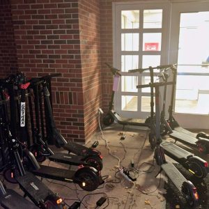 E-scooters stored indoors in a building hallway
