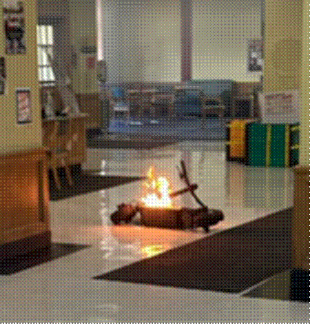 An electric scooter on fire in the middle of a school hallway