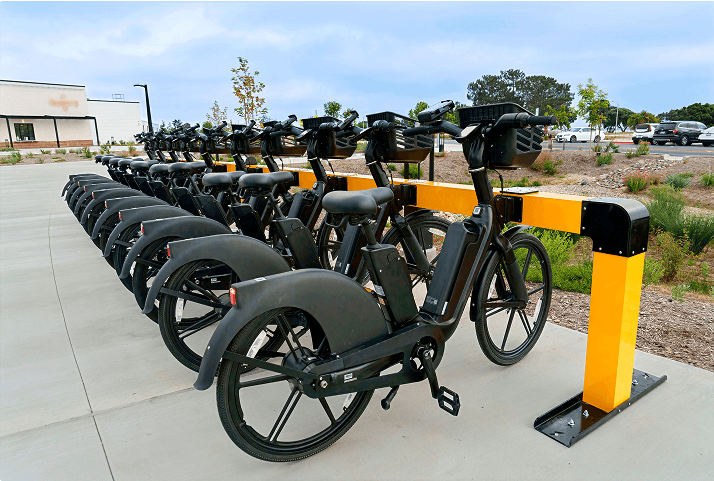 Row of e-bikes docked at a Juise charging station outside a residential building
