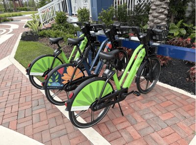 Green and black e-bikes parked on a brick walkway at the Newfield property